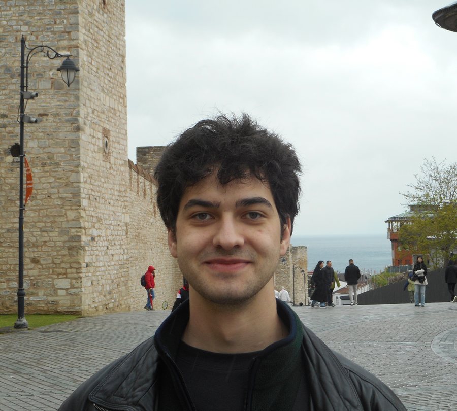 Alexander Weimer unterwegs, im Hintergrund eine alte Stadtmauer und das Meer